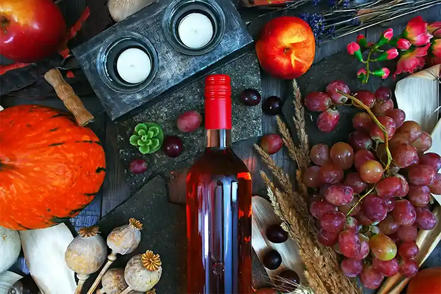 Une bouteille de vinaigre allongée au mileu dde fruits et légumes frais à La Table de 3 à Bordeaux